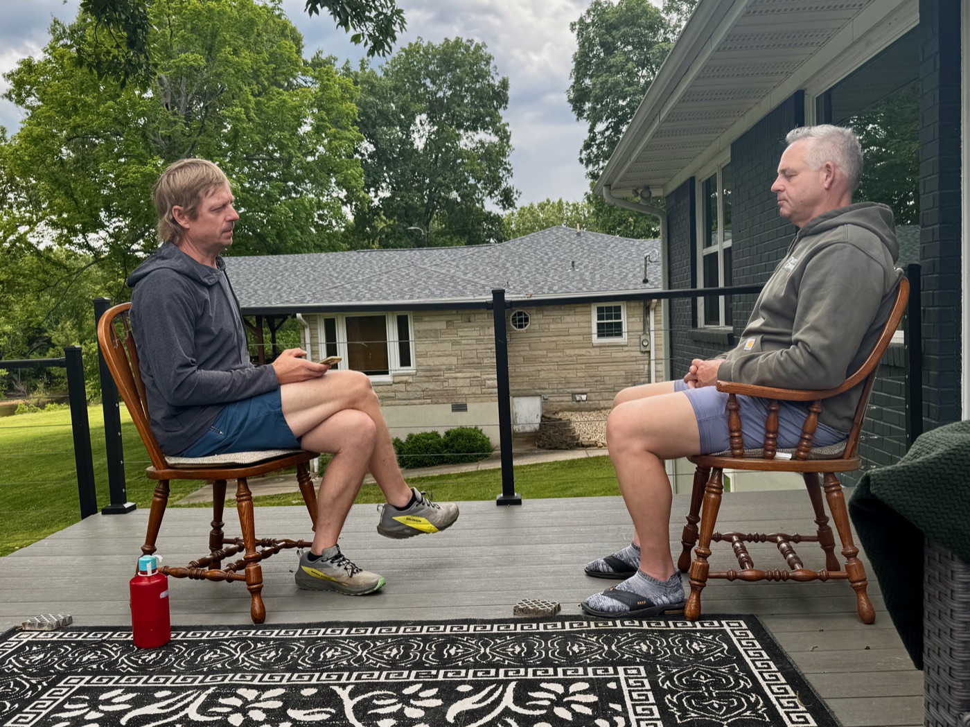 Two men on a porch, present with each other